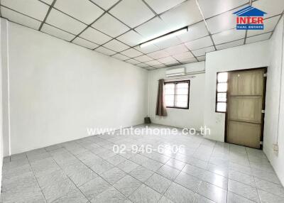 Spacious empty room with tiled floor, window, and air conditioning unit
