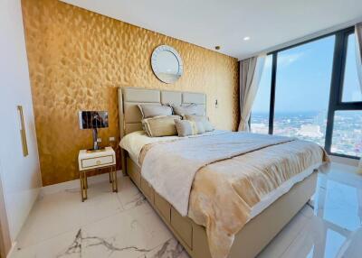 Modern bedroom with gold accent wall and large window