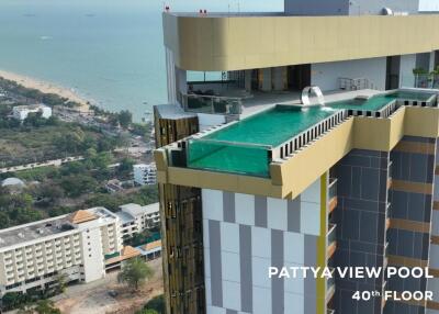 Aerial view of a high-rise building with an infinity pool and ocean view