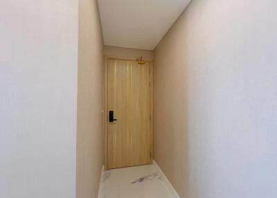 Minimalist hallway with light wooden door and white marble flooring
