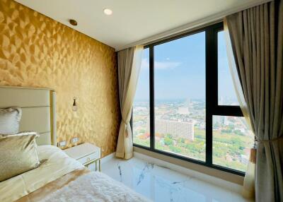 Modern bedroom with a large window offering city views