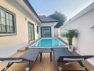 Outdoor pool area with lounge chairs and potted plants