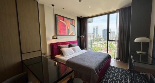 Modern bedroom with a large window, city view, and stylish decor