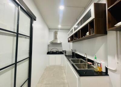 Modern white kitchen with black countertops and open shelving