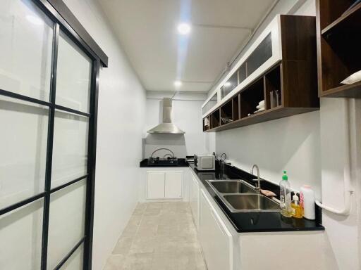 Modern white kitchen with black countertops and open shelving