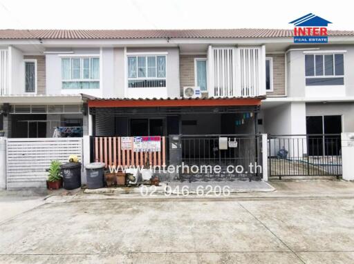 Front view of a townhouse with a small front yard