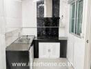 modern kitchen with stainless steel sink and black backsplash