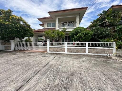 Two-story house exterior with a well-maintained front yard and balcony