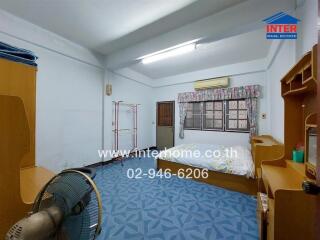 Bedroom with blue patterned floor, bed, and wooden furniture