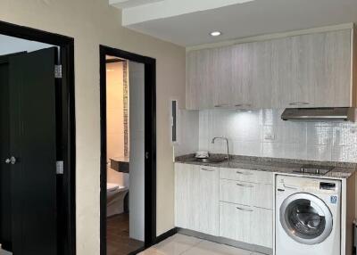 Modern kitchen with washer and adjacent bathroom