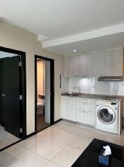 Modern kitchen with washer and adjacent bathroom