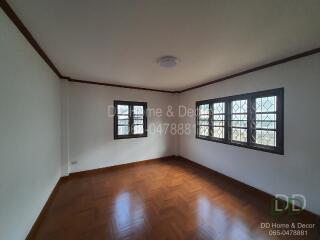 Spacious empty bedroom with wooden floor and large windows