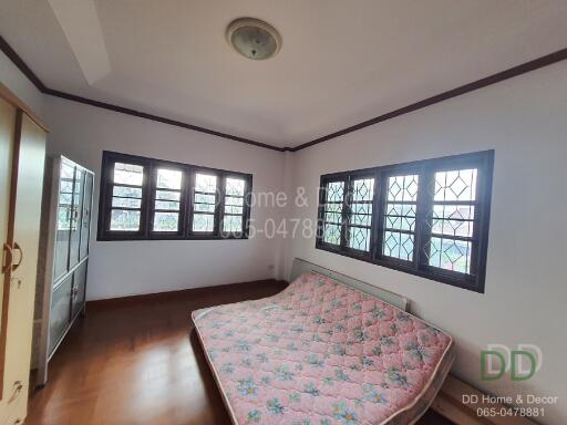 Bedroom with large windows and a mattress on the floor