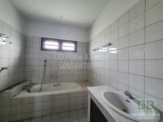 Bathroom with bathtub, sink, and tiled walls