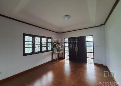 Spacious living room with wooden flooring and large windows