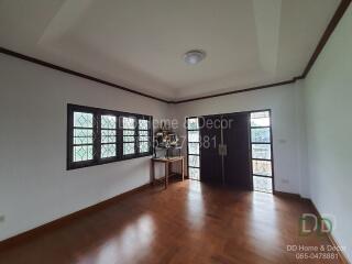 Spacious living room with wooden flooring and large windows