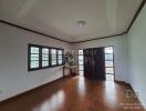 Spacious living room with wooden flooring and large windows