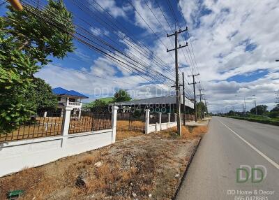 View of a building exterior along a road with blue skies