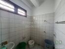 Bathroom with tiled walls and various fixtures