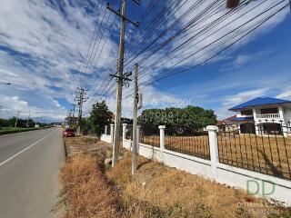 view of road and nearby property with visible power lines and clear sky