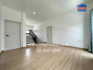 Spacious living area with wooden flooring and staircase