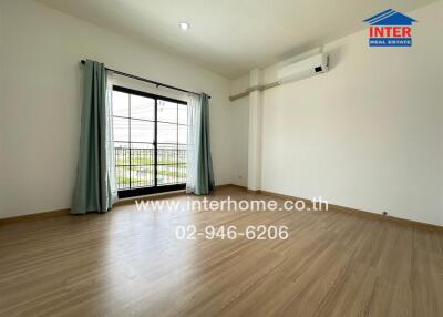 Empty bedroom with large window and air conditioning
