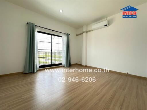 Empty bedroom with large window and air conditioning