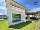 Modern two-story house with large windows and well-maintained lawn