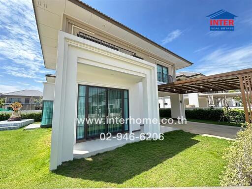 Modern two-story house with large windows and well-maintained lawn