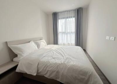 Modern bedroom with a white bed and large window