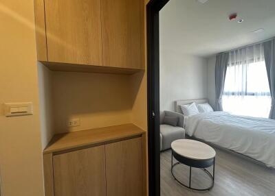 Modern bedroom with large window, couch, and wooden cabinetry