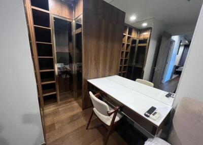 Modern home office with desk and chair, built-in wooden bookshelves, and mirrored walls