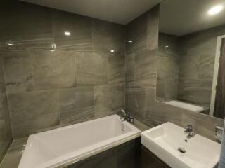 Modern bathroom with bathtub, sink, and large mirror