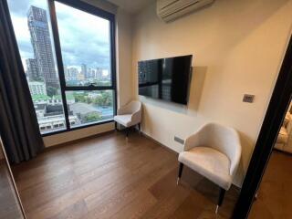 Modern living space with wooden floors, mounted TV, air conditioning, and city view