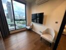 Modern living space with wooden floors, mounted TV, air conditioning, and city view
