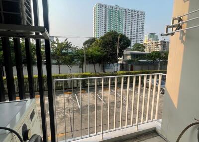 Balcony with view of parking area and city buildings