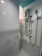 Shower area with water heater and floral decoration