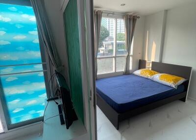 Bedroom with blue bedspread and large windows