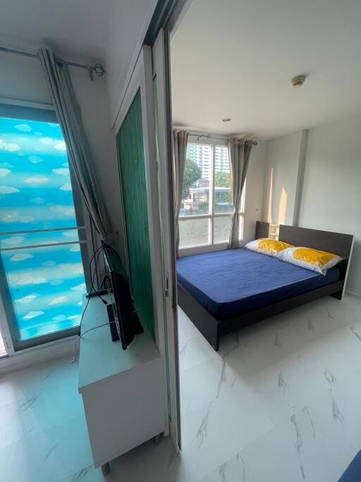 Bedroom with blue bedspread and large windows