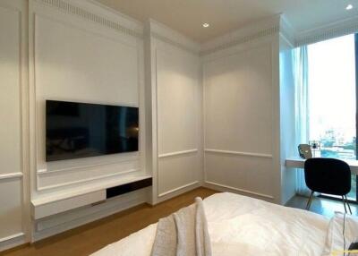 Modern bedroom with a wall-mounted TV and a study desk by the window