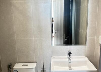 Modern bathroom with mirror, sink, and toilet