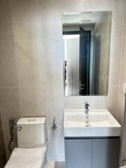 Modern bathroom with mirror, sink, and toilet