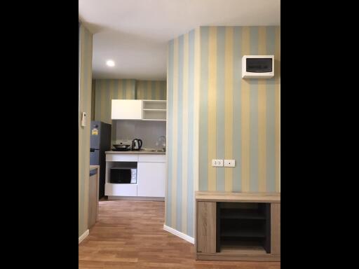 Modern kitchen with striped wallpaper and various appliances