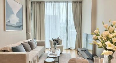 Modern living room with couch, coffee table, large window, and TV