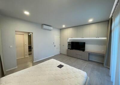 Modern bedroom with bed, wall-mounted TV, and built-in cabinets