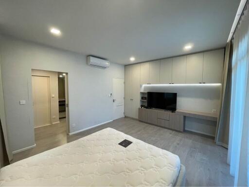 Modern bedroom with bed, wall-mounted TV, and built-in cabinets