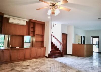 Spacious main living area with marble tile flooring, wooden cabinetry, and ceiling fan.