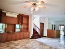 Spacious main living area with marble tile flooring, wooden cabinetry, and ceiling fan.