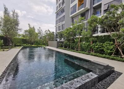 Outdoor swimming pool in front of modern apartment building