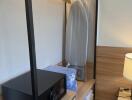 closet with safe and ironing board in bedroom